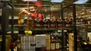 Seorang pria mengisi rak pajangan dengan botol alkohol di sebuah toko ketika Afrika Selatan mencabut larangan penjualan alkohol dan rokok di Johannesburg, Selasa (18/8/2020). Pembelian alkohol dan rokok dilarang ketika Afsel memberlakukan lockdown ketat pada 27 Maret 2020. (AP Photo/Denis Farrell)