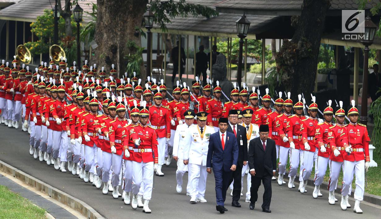 Presiden Joko Widodo didampingi Wapres Jusuf Kalla dan Mendagri Tjahjo Kumolo berjalan saat akan melantik  Gubernur dan Wakil Gubernur Kaltim serta Gubernur dan Wakil Gubernur Sumsel di Istana Negara, Jakarta, Senin (1/10). (Liputan6.com/Angga Yuniar)