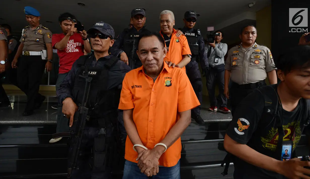 Polisi bersenjata menggiring tersangka dugaan pengaturan skor di Polda Metro Jaya, Jakarta, Rabu (10/4). Sebelum diserahkan ke kejaksaan, polisi lebih dulu mengecek kesehatan para tersangka di Biddokes Polda Metro Jaya. (merdeka.com/Imam Buhori)