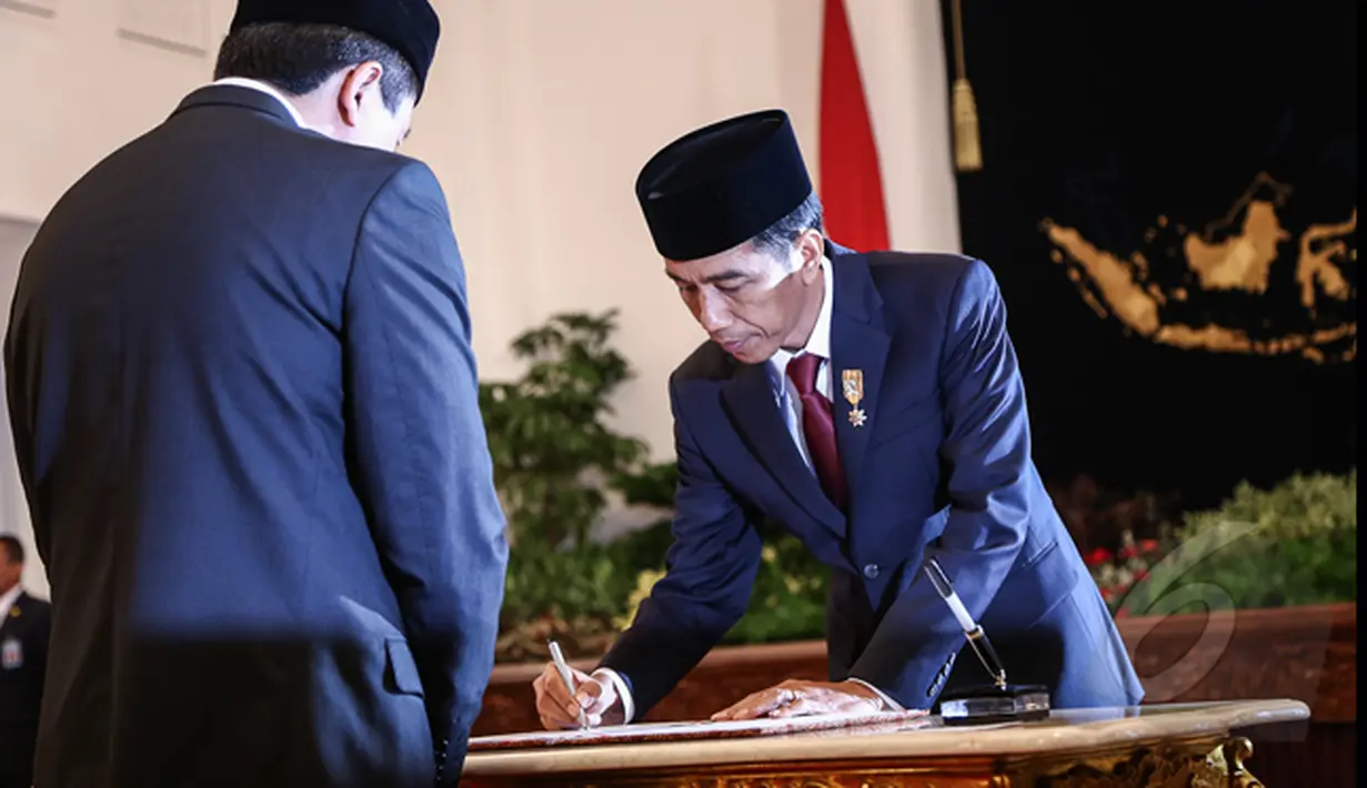 Presiden Joko Widodo menandatangani surat pelantikan Triawan Munaf sebagai Kepala Badan Ekonomi Kreatif di Istana Negara, Jakarta, Senin (26/1/2015). (Liputan6.com/Faizal Fanani)