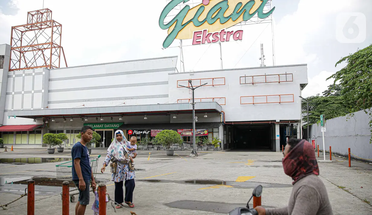 Pengunjung melintas di depan Supermarket Giant Ekstra di Kreo, Tangerang, Senin (2/8/2021). PT Hero Supermarket Tbk resmi menutup seluruh gerai Giant di Indonesia pada Minggu (1/8/2021), dan akan lebih fokus pada pengembangan gerai merek lainnya. (Liputam6.com/Faizal Fanani)