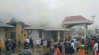 Petugas pemadam kebakaran memadamkan api yang membakar sebuah rumah di Desa Mongolato, Kecamatan Talaga, Kabupaten Gorontalo, Rabu (16/3/2022). Foto: gopos (Arfandi Ibrahim/Liputan6.com)