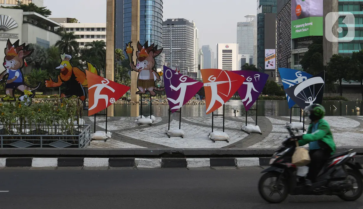 Pengendara sepeda motor melintas di dekat maskot Pekan Olahraga Nasional (PON) XX Papua di Bundaran Hotel Indonesia, Jakarta, Jumat (16/07/2021). Presiden Joko Widodo memastikan PON XX Papua tetap akan berlangsung pada 2-15 Oktober 2021. (Liputan6.com/Herman Zakharia)