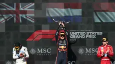 Pembalap tim Red Bull Racing asal Belanda, Max Verstappen (tengah) mengangkat trofi di podium bersama Lando Norris (McLaren, kiri) yang finis di posisi kedua dan Charles Leclerc (Ferrari) yang finis di posisi ketiga, setelah balapan Formula Satu Grand Prix Amerika Serikat di Sirkuit of the Americas di Austin, Texas, pada Minggu 19 Oktober 2025. (RONALDO SCHEMIDT/AFP)