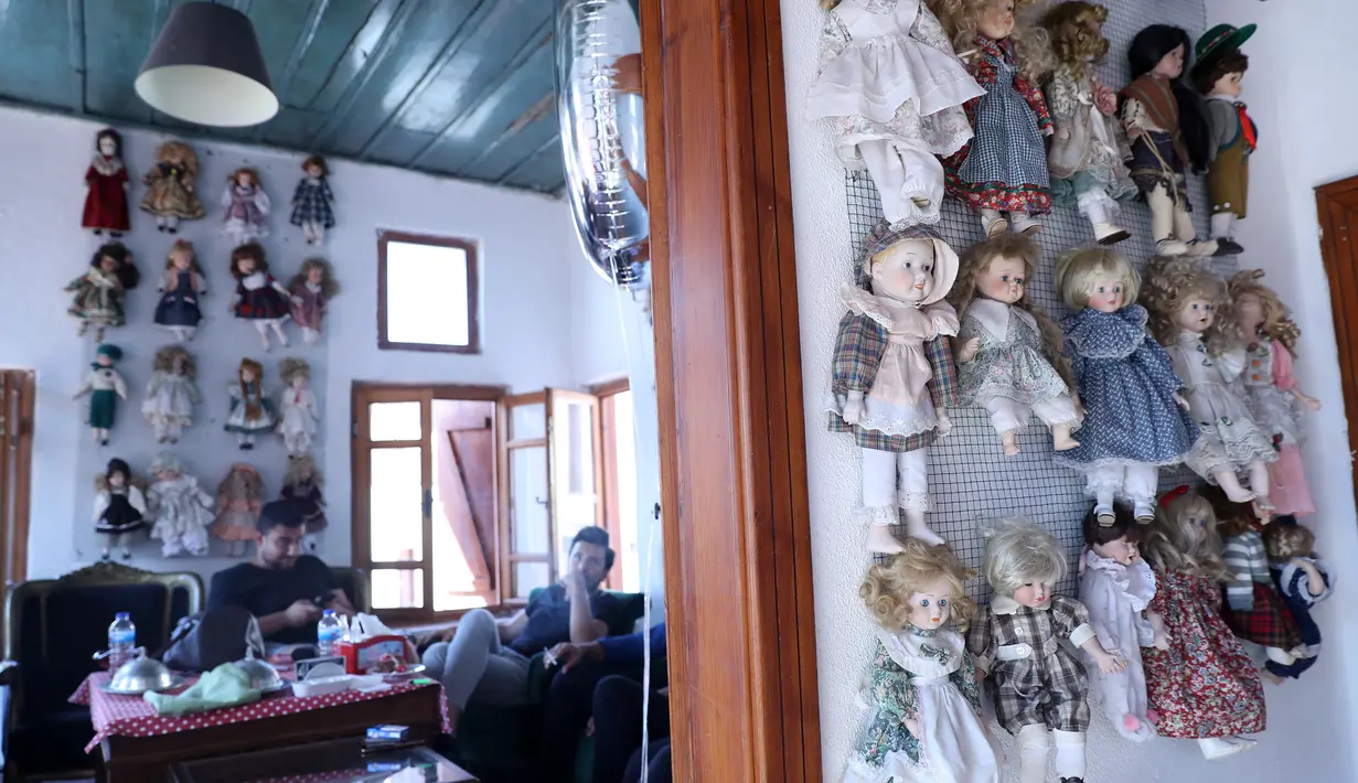 Pengunjung menikmati pesanan dengan boneka yang dipajang di kedai kopi Turki bernama Ankara Castle di Ankara, 8 Agustus 2019. Kedai kopi itu menyambut pengunjung dengan koleksi unik sebanyak 7.500 boneka porselen dari 81 negara yang dikumpulkan pemiliknya selama lebih dari 20 tahun. (Adem ALTAN/AFP)