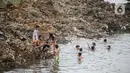 Anak-anak bermain di Sungai Ciliwung yang surut di kawasan Bukit Duri, Jakarta, Sabtu (8/8/2020). Penyusutan debit air Sungai Ciliwung tersebut karena memasuki masa kemarau 2020 yang menurut BMKG akan mencapai puncaknya pada Agustus. (Liputan6.com/Faizal Fanani)