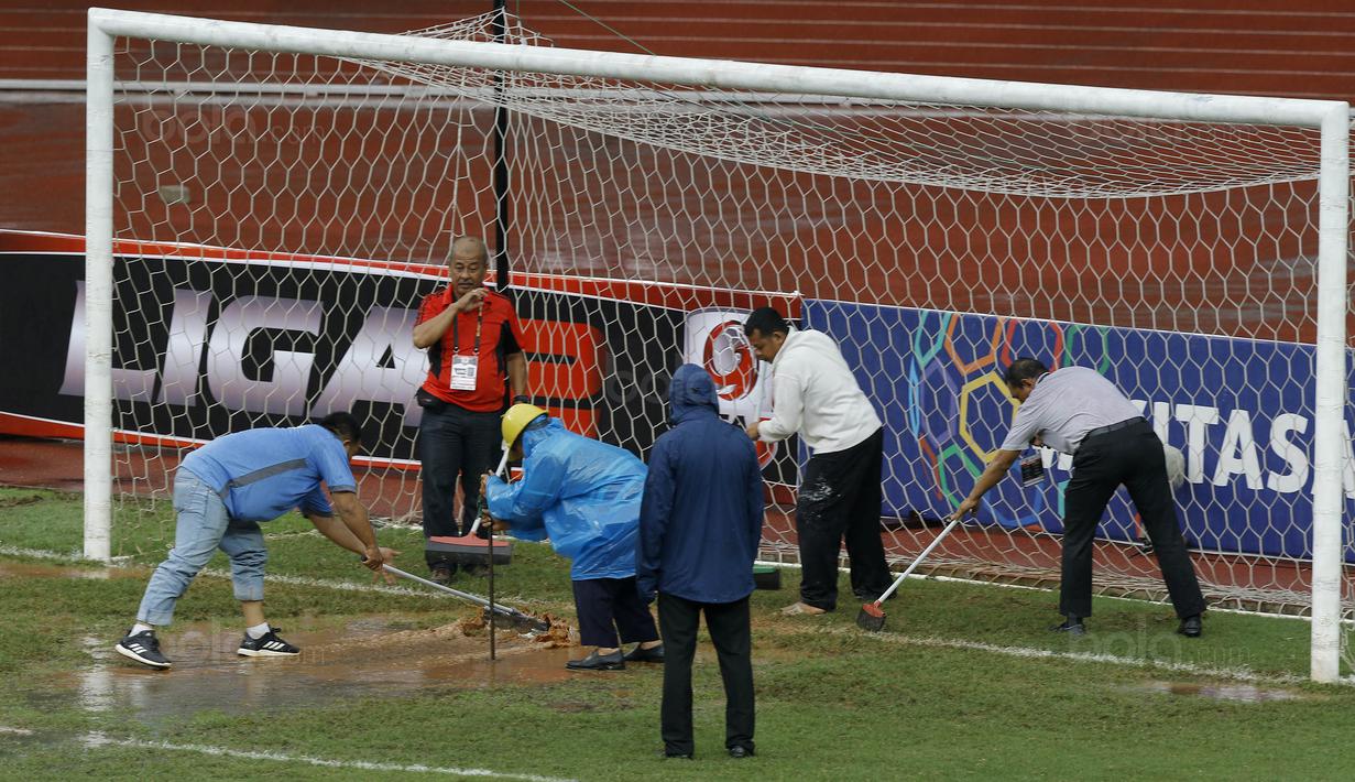 Para petugas berusaha menguras air yang menggenangi lapangan di Stadion Patriot, Bekasi, Senin (13/11/2017). Drainase yang buruk menyebabkan lapangan terendam air. (Bola.com/M Iqbal Ichsan)