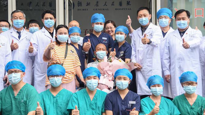 Cui dan keluarganya foto bersama para petugas medis di Rumah Sakit Renmin Universitas Wuhan di Wuhan, Provinsi Hubei, China (21/7/2020). Cui, pasien COVID-19 yang menjalani operasi transplantasi paru-paru ganda, sembuh setelah perawatan selama berbulan-bulan dan dipulangkan. (Xinhua/Cheng Min)