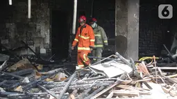Petugas pemadam kebakaran berjalan di antara sisa kebakaran gedung Hailai di kawasan Ancol, Jakarta Utara, Selasa (5/11/2019). Tidak ada korban jiwa dalam kebakaran yang diduga  karena percikan api dari aktivitas pembongkaran yang menggunakan mesin las. (Liputana6.com/Faizal Fanani)