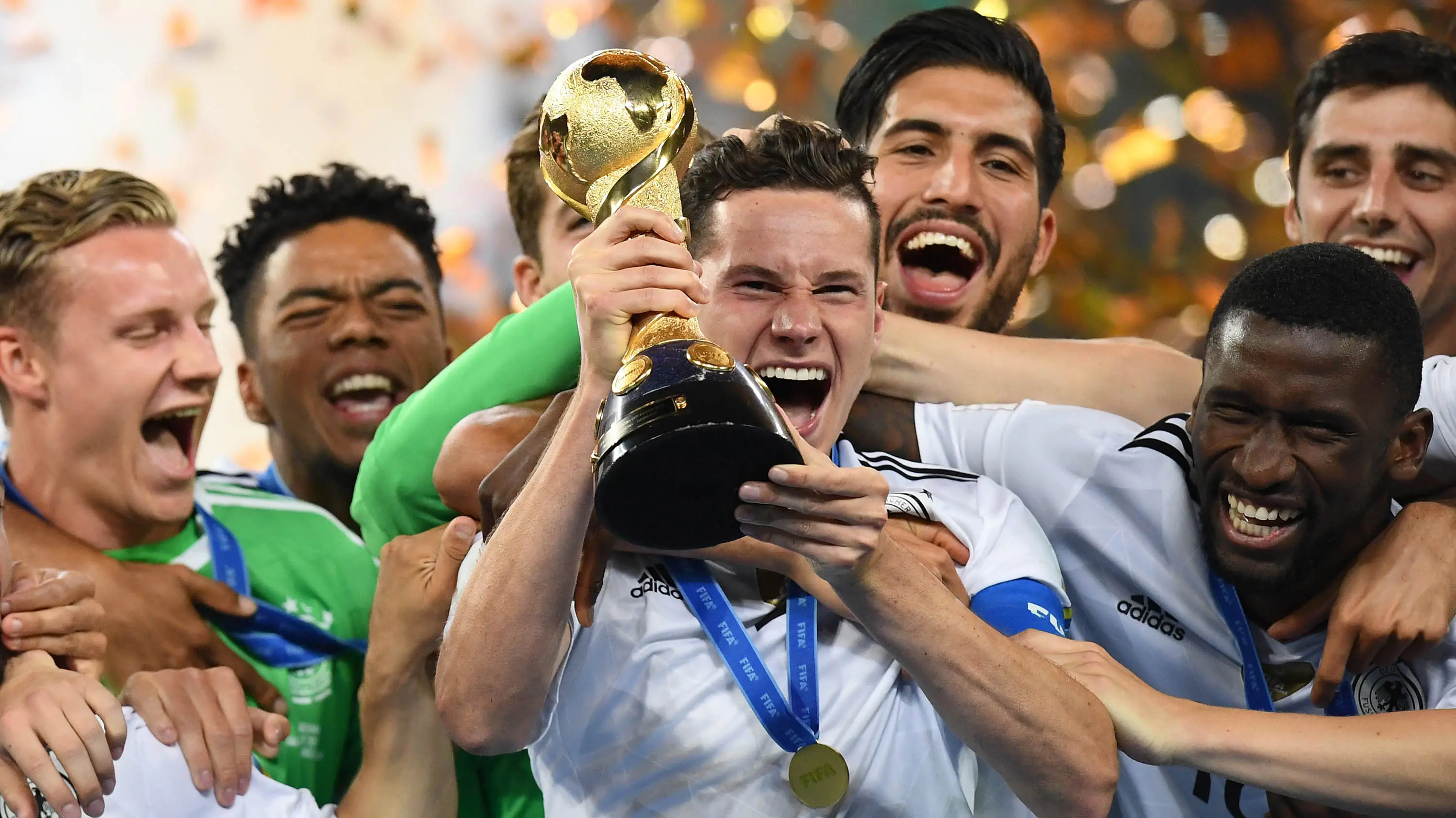 Gelandang Jerman, Julian Draxler, memegang piala merayakan gelar juara Piala Konfederasi di Stadion Saint Petersburg, Rusia, Minggu (2/7/2017). (AFP/Franck Fife)