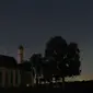 Sebuah meteor melintas di tengah langit malam selama hujan meteor tahunan Perseid di belakang gereja ziarah Sankt Coloman, barat daya Jerman, Minggu (12/8). Puncak hujan meteor terjadi pada 11-12 Agustus dan 12-13 Agustus. (KARL-JOSEF HILDENBRAND/DPA/AFP)