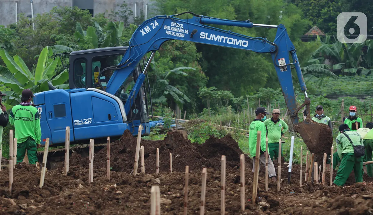 Aktivitas alat berat jenis eksavator membantu proses penggalian makam jenazah dengan protokol COVID-19 di area khusus TPU Srengseng Sawah, Jakarta, Kamis (14/1/2021). Pada Selasa (12/1) lalu, 47 jenazah dimakamkan dengan protokol COVID-19 di TPU Srengseng Sawah. (Liputan6.com/Helmi Fithriansyah)