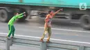 Anak-anak bermain dengan melambaikan tangan di area pembatas jalan tol di Kawasan Jatimulya, Bekasi, Jawa Barat, Rabu (24/5/2023). (merdeka.com/imam buhori)