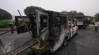 Sisa kendaraan milik kepolisian yang dibakar saat bentrokan di tengah demo 4 November, di kawasan Monas, Jakarta, Sabtu (5/11). Pengunjung menjadikan dua kendaraan milik kepolisianitu sebagai objek foto dan melakukan swafoto. (Liputan6.com/Angga Yuniar)