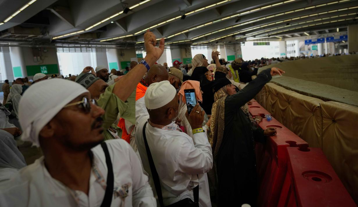Jemaah Muslim melemparkan kerikil ke tiang-tiang sebagai simbol pelemparan batu ke setan pada hari kedua ritual, salah satu upacara terakhir ibadah haji tahunan, di Mina, Arab Saudi, Kamis 28 Mei 2026. (AP Photo/Altaf Qadri)
