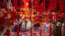 Bagi masyarakat China, Imlek memiliki makna sebagai simbol identitas dan jalinan ikatan keluarga yang kuat. Tampak dalam foto, para pembeli memeriksa dekorasi Tahun Baru Imlek di sebuah pasar di Beijing, China, Rabu 4 Februari 2026. (AP Photo/Vincent Thian)