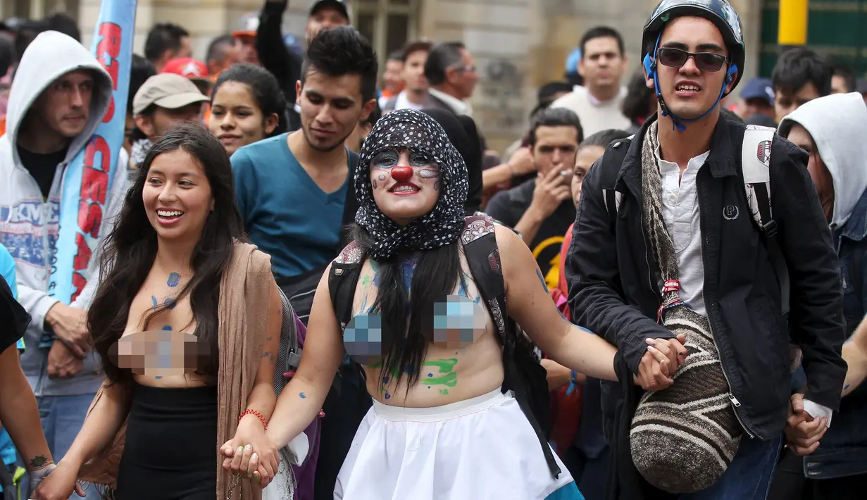 Ribuan mahasiswa bertelanjang dada menggelar aksi mogok nasional di Bogota, Kolombia, (17/3). Aksi tersebut merupakan protes terhadap sejumlah kebijakan pemerintah. (REUTERS/John Vizcaino)