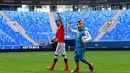 Maskot resmi Piala Eropa 2020, Skillzy dan pemain Rusia, Alexander Erokhin menyapa penonton saat presentasi di Stadion Saint Petersburg, Rusia (27/3). Kota Saint Petersburg akan menyelenggarakan empat pertandingan termasuk pertandingan perempat final selama UEFA Euro 2020. (AFP Photo/Olga Maltseva)