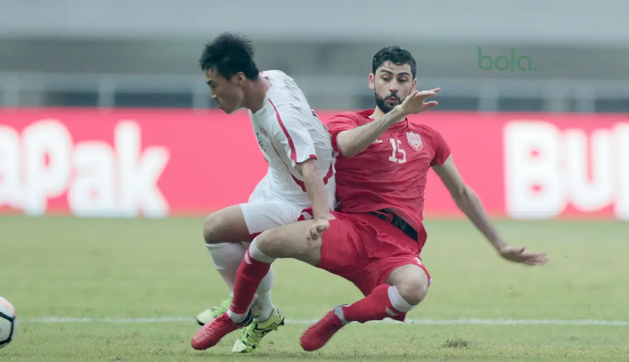 Pemain Bahrain U-23, Hasan Alkarrani (kanan) beebut bola dengan pemain Korea Utara U-23 pada laga PSSI Anniversary Cup 2018 di Stadion Pakansari, Bogor, (03/5/2018). Bahrain menang 4-1. (Bola.com/Nick Hanoatubun)