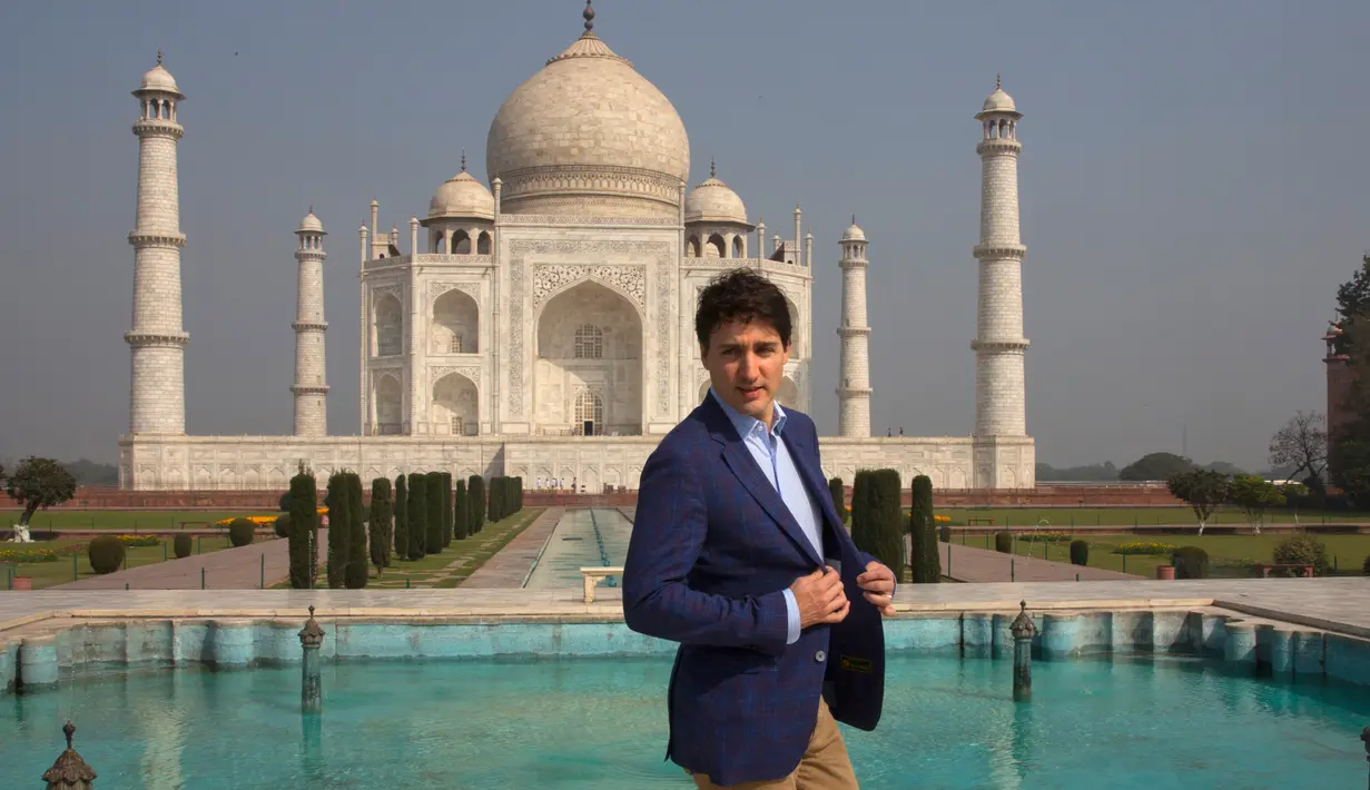 Perdana Meneteri (PM) Kanada Justin Trudeau merapikan jasnya sebelum berpose di depan Taj Mahal di sela-sela kunjungan ke India, Minggu (18/2). PM Kanada mengunjungi Taj Mahal bersama istri dan anak-anaknya. (AP/Manish Swarup)