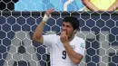 Striker tim nasional Uruguay, Luis Suarez terlihat memegangi mulutnya pada pertandingan penyisihan Piala Dunia Grup D 2014 di Dunas, Brasil, Selasa (24/6/14). (REUTERS/Yves Herman)