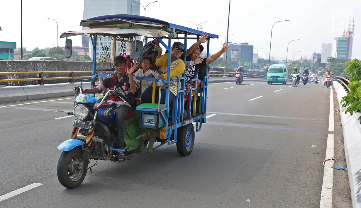 Sejumlah warga menaiki bak terbuka motor roda tiga menuju Kebun Binatang Ragunan di kawasan Jakarta, Minggu (9/6/2019). Masyarakat memanfaatkan motor roda tiga untuk bepergian saat libur lebaran karena dianggap lebih hemat biaya. (Liputan6.com/Herman Zakharia)