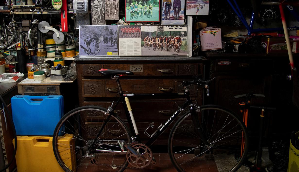 Sebuah gambar menunjukkan Raffaello Bianco, mekanik dan pecinta sepeda di bengkel mekaniknya di ruang bawah tanah apartemennya di Turin, Italia, 7 Juli 2020. Raffaello Bianco adalah montir sepeda amatir yang sedang memperbaiki sepeda di garasi kecil dekat rumahnya. (MARCO BERTORELLO/AFP)