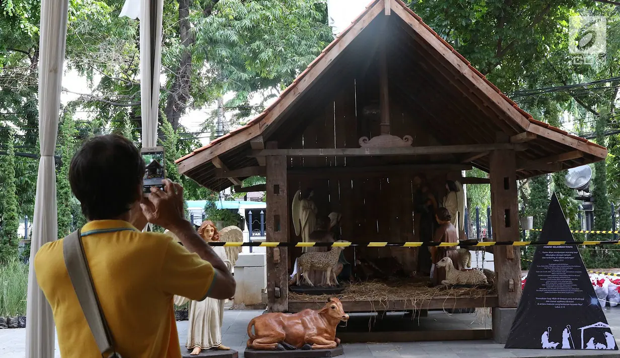 Jemaat mengambil gambar dekorasi Natal di Gereja Katedral, Jakarta, Kamis (20/12). Gereja Katedral menyambut perayaan Misa Natal dengan mendirikan tenda dan dekorasi. (Liputan6.com/Immanuel Antonius)