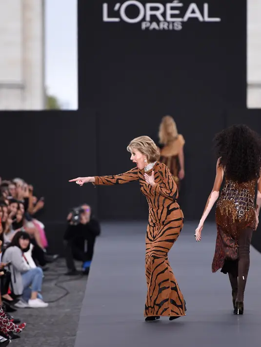 Aktris legendaris, Jane Fonda menunjukkan ke arah kerumunan penonton ketika menjadi model fashion show untuk L'Oreal di Paris Fashion Week, Minggu (1/10). Nenek satu cucu itu terlihat masih sehat meski di usia senjanya. (AP Photo/Kamil Zihnioglu)