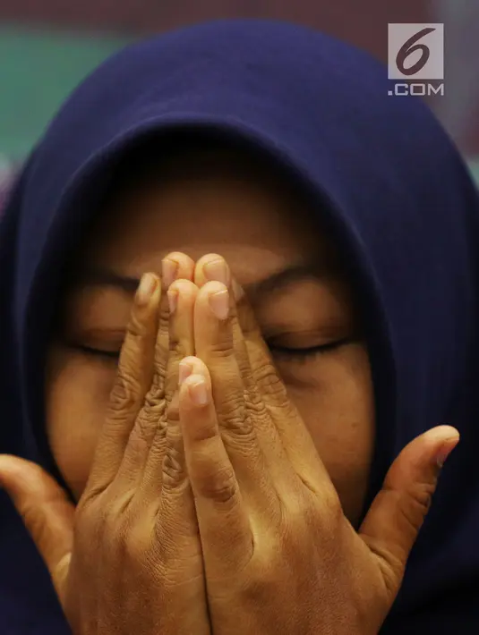 Terpidana kasus pelanggaran UU ITE Baiq Nuril menutupi wajahnya saat berbicara dalam diskusi Dialektika Demokarasi di Kompleks Parlemen Senayan, Jakarta, Rabu (10/7/2019). Baiq mengaku tidak ingin kasusnya berlarut-larut dan menjadi konsumsi publik seperti sekarang. (Liputan6.com/JohanTallo)