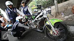 Petugas Dishub mencabut pentil kendaraan roda dua dalam operasi penertiban parkir liar di Pusat, Jumat (23/10/2015). Meskipun informasi penertiban diduga telah bocor, ratusan kendaraan yang parkir liar tetap ditertibkan. (Liputan6.com/Immanuel Antonius)