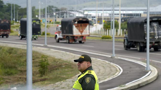 Polisi mengawal truk-truk bantuan kemanusiaan untuk Venezuela menuju Jembatan Tienditas di perbatasan Kolombia-Venezuela, Cucuta, Kolombia, Kamis (7/2). Kedatangan bantuan bertepatan dengan pertemuan menteri Eropa dan Amerika Latin. (RAUL ARBOLEDA/AFP)
