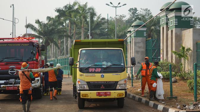 Petugas mengangkut sampah sisa bentrok antara mahasiswa dan polisi dalam unjuk rasa di depan Gedung DPR RI, Jakarta, Rabu (25/9/2019). Bentrokan pada Selasa (24/9/2019) menyisakan sampah yang memenuhi kawasan di sekitar Gedung DPR. (Liputan6.com/Immanuel Antonius)