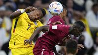 Pemain Timnas Ekuador, Pervis Estupinan (kiri) berduel udara dengan pemain Timnas Qatar, Almoez Ali dalam laga matchday pertama Grup A Piala Dunia 2022 di Al-Bayt Stadium, Qatar, Minggu (20/11/2022) malam WIB. (AP/Manu Fernandez)