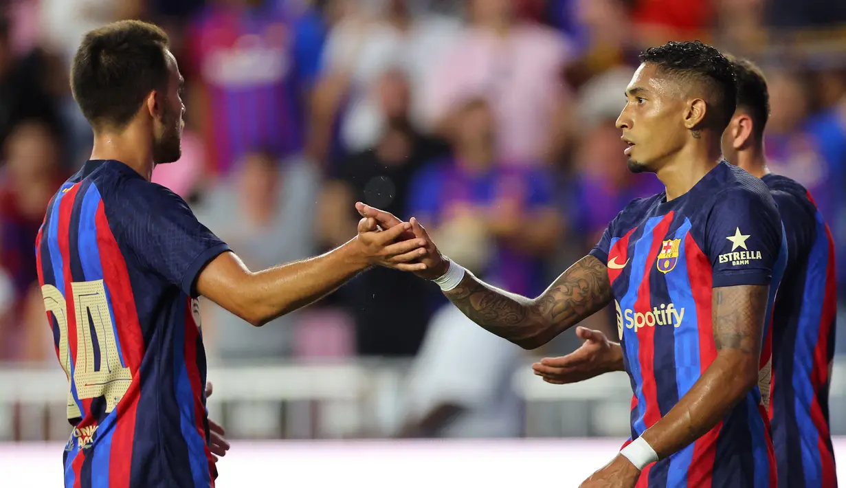 Penyerang Barcelona, Raphinha (kanan) berselebrasi dengan rekannya Eric Garcia usai mencetak gol ke gawang Inter Miami FC pada pertandingan persahabatan pramusim di DRV PNK Stadium di Fort Lauderdale, Florida (19/7/2022). Bercelona menang telak atas Inter Miami 6-0. (AFP/Michael Reaves)