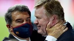 Presiden Barcelona, Joan Laporta, melakukan selebrasi bersama Ronald Koeman usai menjuarai Copa del Rey di Stadion Olimpico de Sevilla, Minggu (18/4/2021). Barcelona menang 4-0 atas Athletic Bilbao. (AFP/Cristina Quicler)