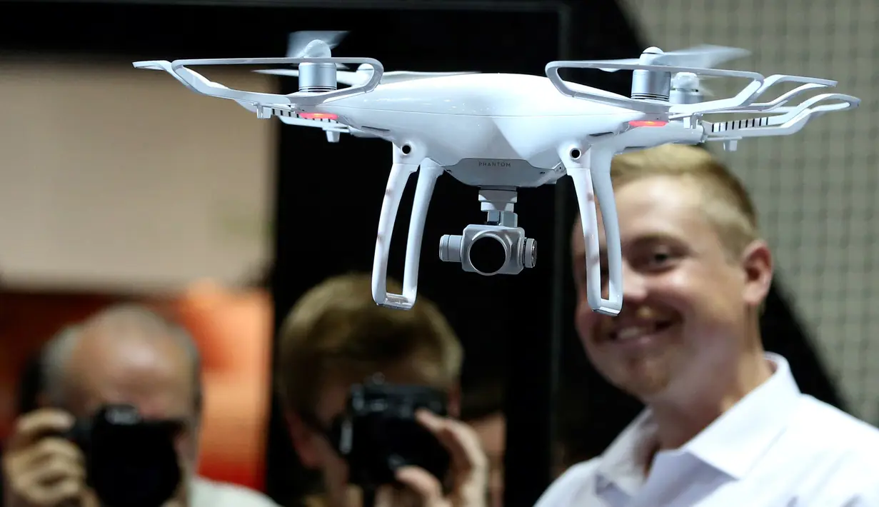 Seorang staff memperlihatkan kecanggihan drone DJI Phantom 4 Quadcopter kepada pengunjung saat berlangsungnya Pameran Photokina di Cologne, Jerman, (20/9). Pameran ini berlangsung 20-25 September 2016. (REUTERS/Fabrizio Bensch)