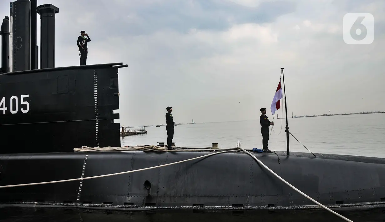 Prajurit TNI AL mengibarkan bendera Merah Putih saat hendak berlayar menggunakan kapal selam KRI Alugoro-405, Dermaga 100, Tanjung Priok, Jakarta Utara, Senin (28/11/2022). KRI Alugoro-405 sendiri merupakan kapal selam buatan dalam negeri yang mempunyai panjang 61,3 meter dengan kecepatan 21 knot dan mampu berlayar lebih dari 50 hari serta dapat menampung 40 kru. (merdeka.com/Iqbal S Nugroho)