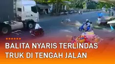 Seorang balita nyaris terlindas truk di tengah jalan mengundang perhatian.