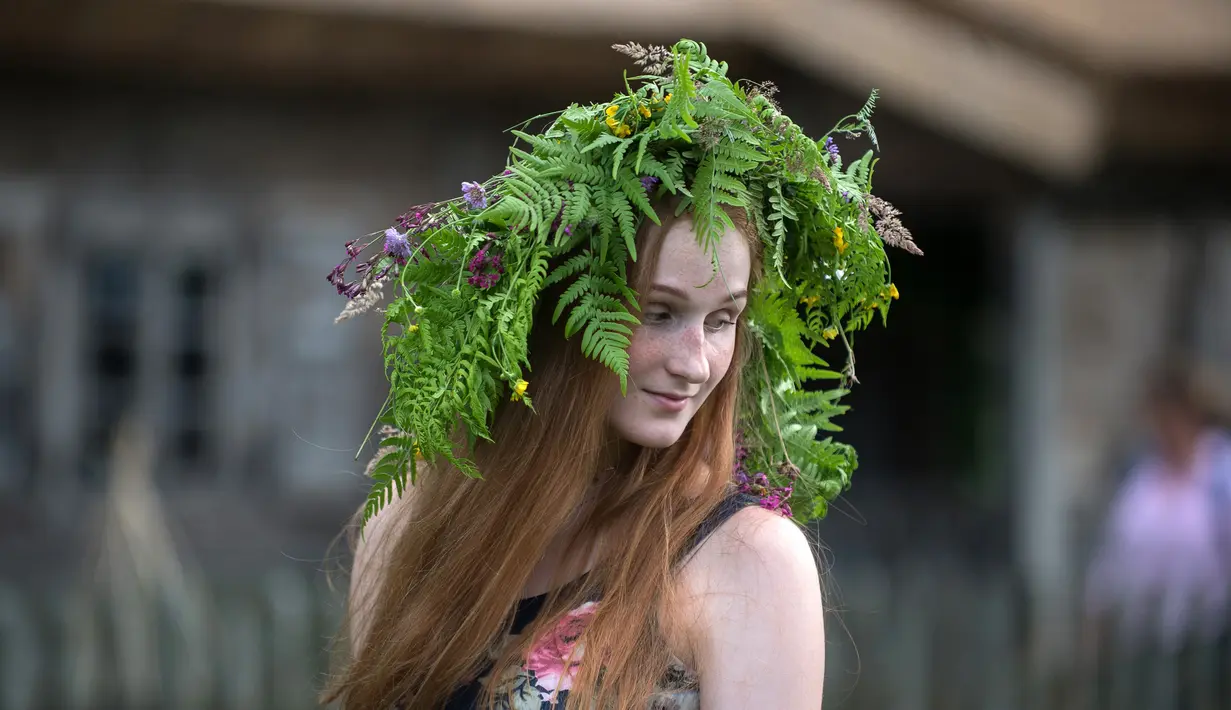Seorang wanita mengenakan mahkota dari bunga saat mengikuti Festival Rasos di Rumsiskes, Lithuania, Selasa (23/6/2020). Festival Rasos merupakan perayaan yang diadakan pada pertengahan musim panas di Lithuania. (Xinhua/Alfredas Pliadis)
