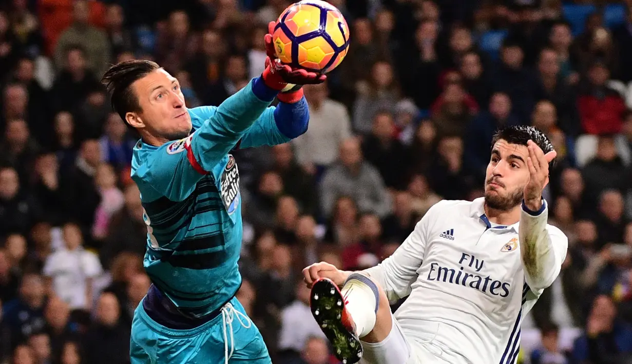 Striker Real Madrid, Alvaro Morata, berusaha mengganggu kiper Deportivo La Coruna, Przemyslaw Tyton, pada pekan ke-15 La Liga Spanyol di Santiago Bernabeu, Sabtu (10/12/2016). (AFP/Pierre-Philippe Marcou)