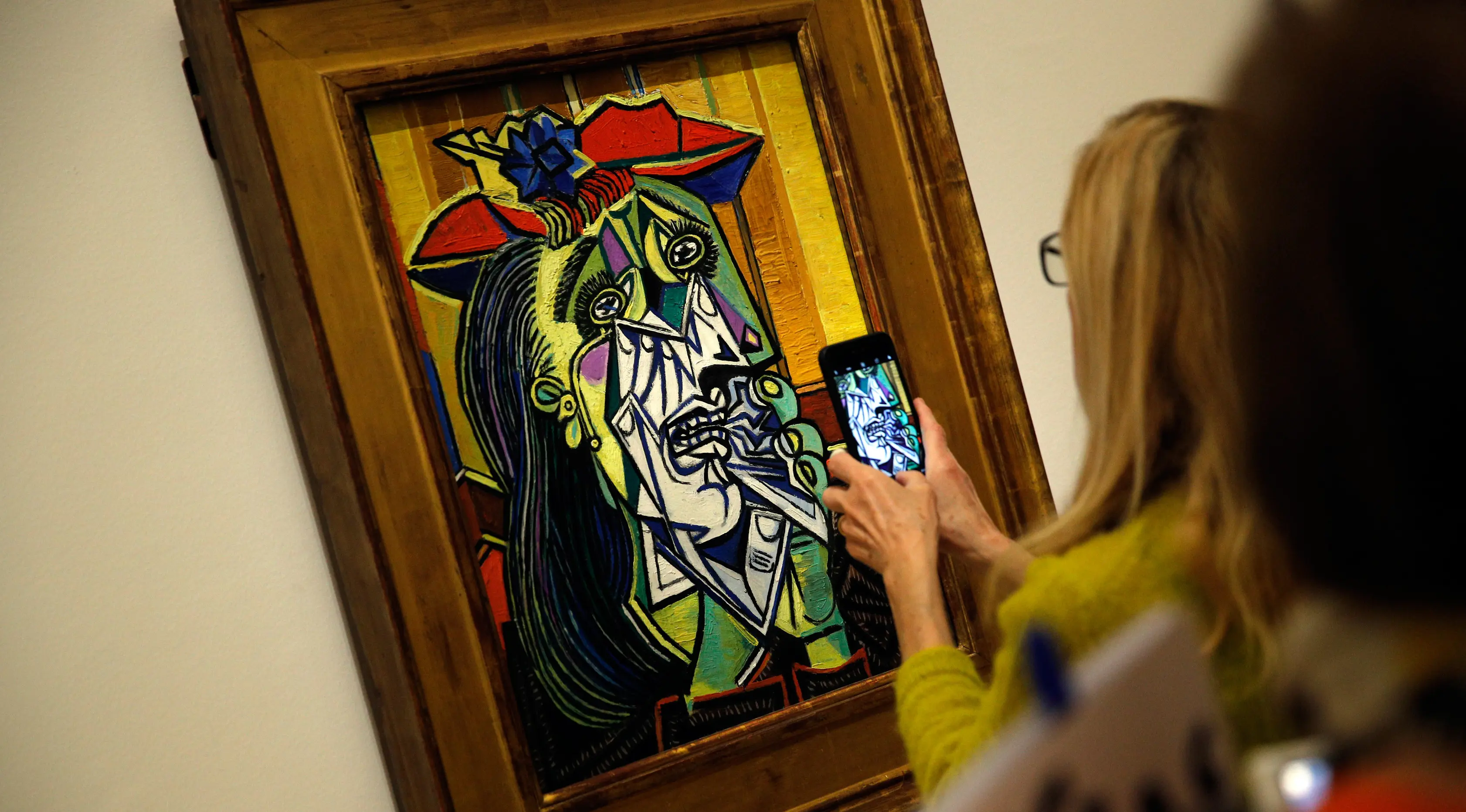 Pengunjung mengambil gambar lukisan berjudul Femme en pleurs karya Pablo Picasso di Museum Picasso, Paris, Prancis, Jumat (23/3). Pameran ini kerja sama Musée national Picasso-Paris dan Museo Nacional Centro de Arte Reina Sofía. (AP Photo/Christophe Ena)