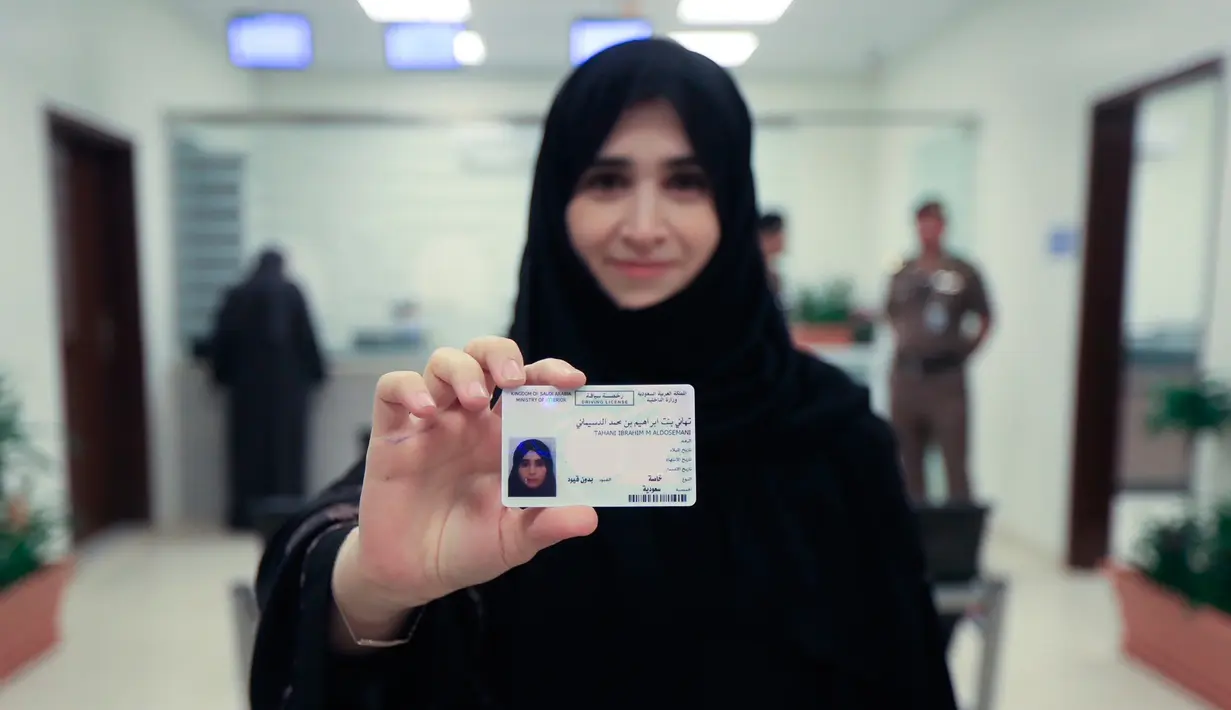 Tahani Aldosemani memperlihatkan surat izin mengemudi (SIM) miliknya di Departemen Lalu Lintas Umum di ibu kota Riyadh, Senin (4/6). Pemerintah Arab Saudi resmi mengeluarkan lisensi mengemudi untuk para wanita di sana. (Saudi Information Ministry via AP)