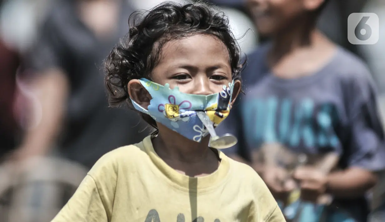 Seorang anak dengan masker mengikuti lomba memperingati HUT ke-75 RI di Kampung Nelayan, Cilincing, Jakarta, Senin (17/8/2020). Meski dilarang menggelar perlombaan akibat Covid-19, warga di Kampung Nelayan tetap mengadakan lomba 17-an walaupun hanya beberapa jenis. (merdeka.com/Iqbal Nugroho)