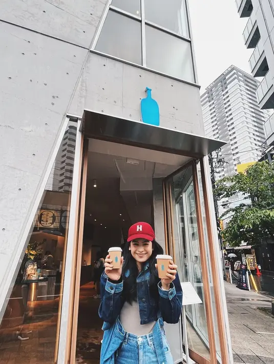 Berpose memegang dua cup kopi, Maudy Ayunda kembali tampil kasual. Kali ini, ia memilih tampilan denim on denim. Foto: Instagram.