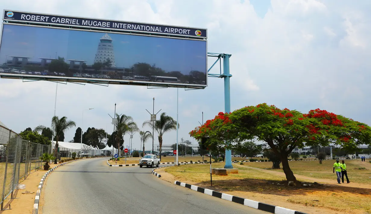 Kendaraan melaju di bawah papan reklame pintu masuk Bandara Robert Mugabe yang baru berganti nama, di Harare, Kamis (9/11). Nama baru bandara yang sebelumnya Bandara Harare itu diambil dari nama Presiden Zimbabwe, Robert Mugabe. (AP/Tsvangirayi Mukwazhi)