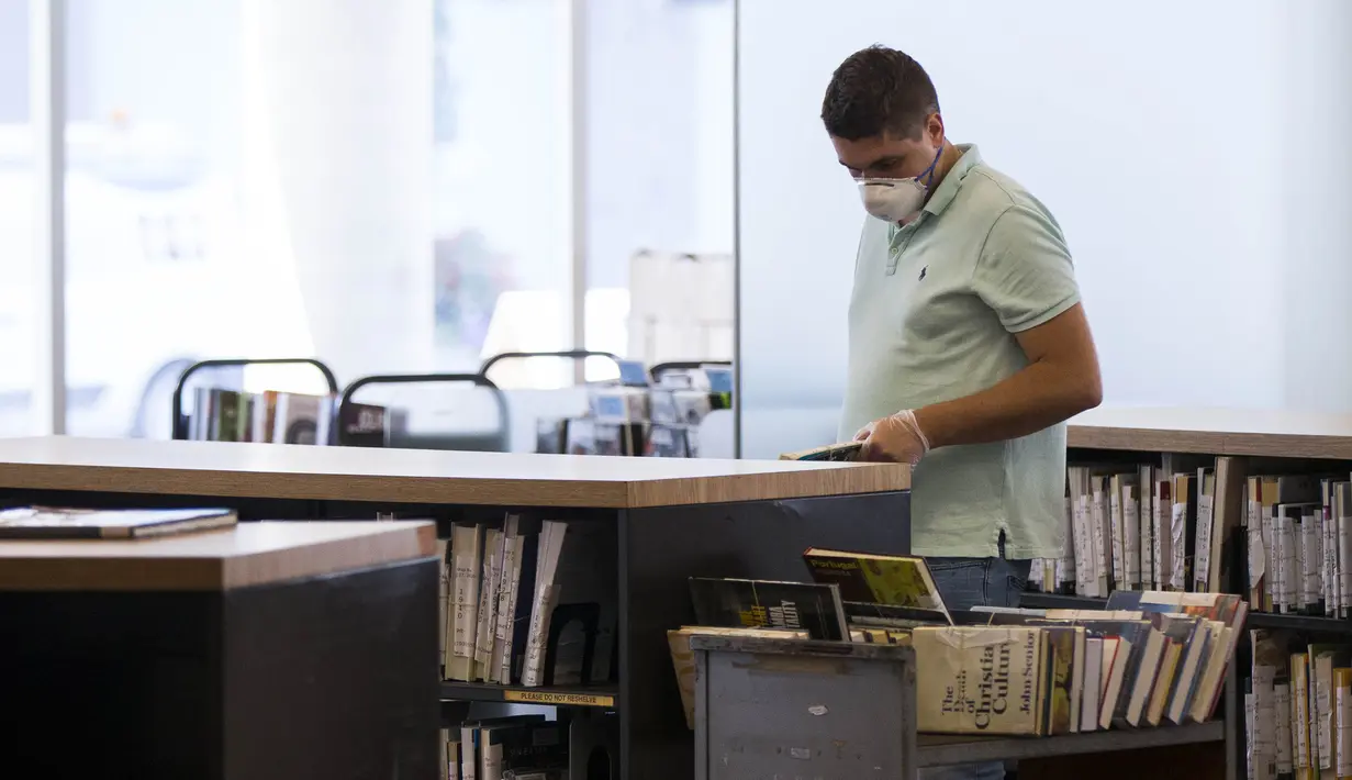 Seorang staf memakai masker menyusun buku di perpustakaan di Toronto, Kanada (24/8/2020). Masyarakat dapat masuk ke dalam perpustakaan untuk mencari dan meminjam buku, menggunakan Wi-Fi, dan mengakses layanan referensi cepat, serta bekerja, belajar, mencetak, atau memfotokopi. (Xinhua/Zou Zheng)