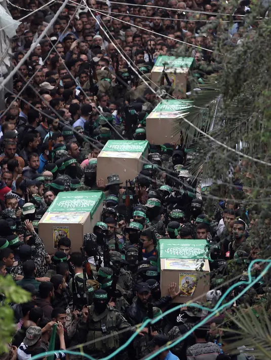 Sejumlah peti jenazah pejuang Hamas yang tewas di Deir el-Balah dibawa untuk dimakamkan di Jalur Gaza (6/5). Media Gaza melaporkan ledakan itu adalah "kecelakaan kerja", akibat kesalahan penanganan bahan peledak. (AP/Khalil Hamra)