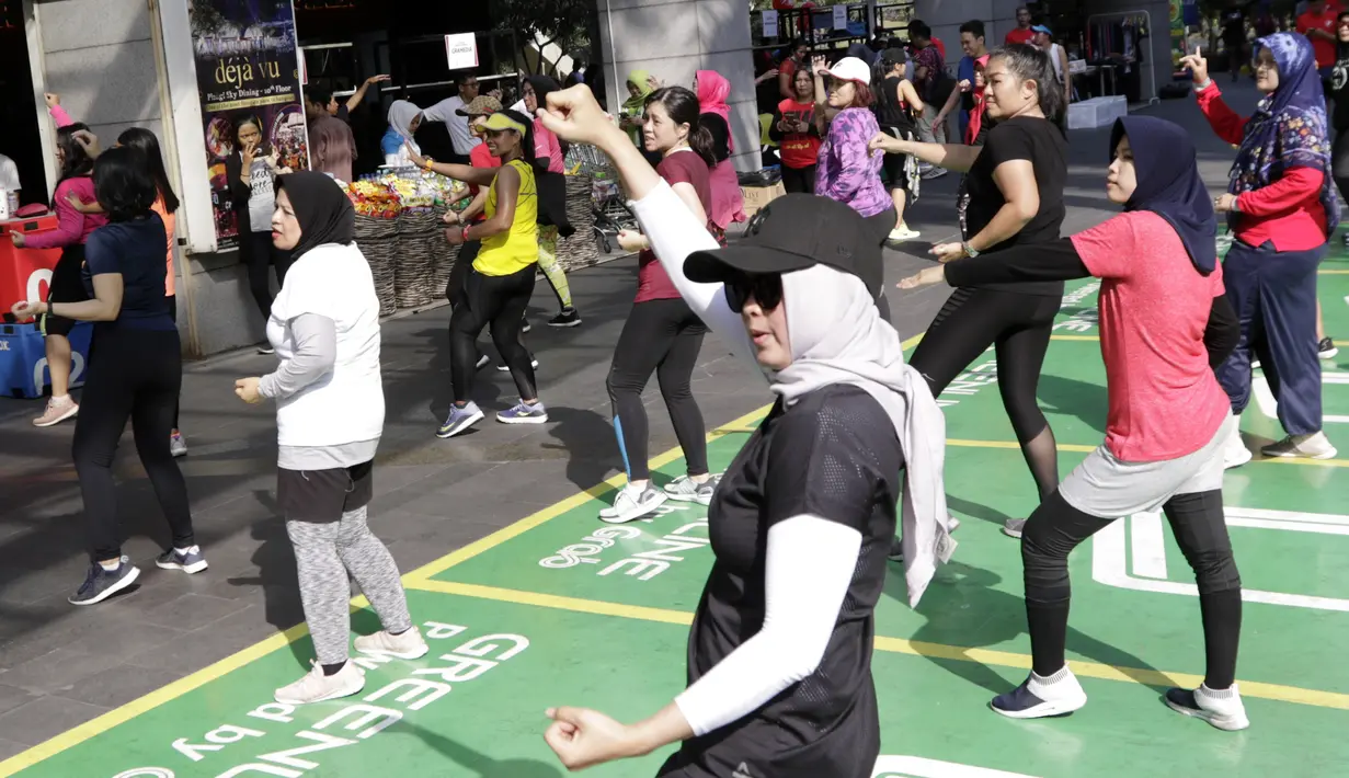 Sejumlah warga mengikuti senam Zumba di Kawasan Semanggi, Jakarta, Minggu (6/10/2019). Selain bisa membakar kalori dan bermanfaat untuk kesehatan jantung, olahraga ini juga bisa mencegah stress dan memperbaiki mood. (Bola.com/M Iqbal Ichsan)