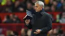 Pelatih Tottenham Hostpur, Jose Mourinho membawa buku saat pertandingan melawan Manchester United pada lanjutan Liga Inggris di Old Trafford, Rabu (4/12/2019). Mourinho gagal mengalahkan Manchester United mantan klub yang pernah dilatihnya. (AFP Photo/Oli Scarff)